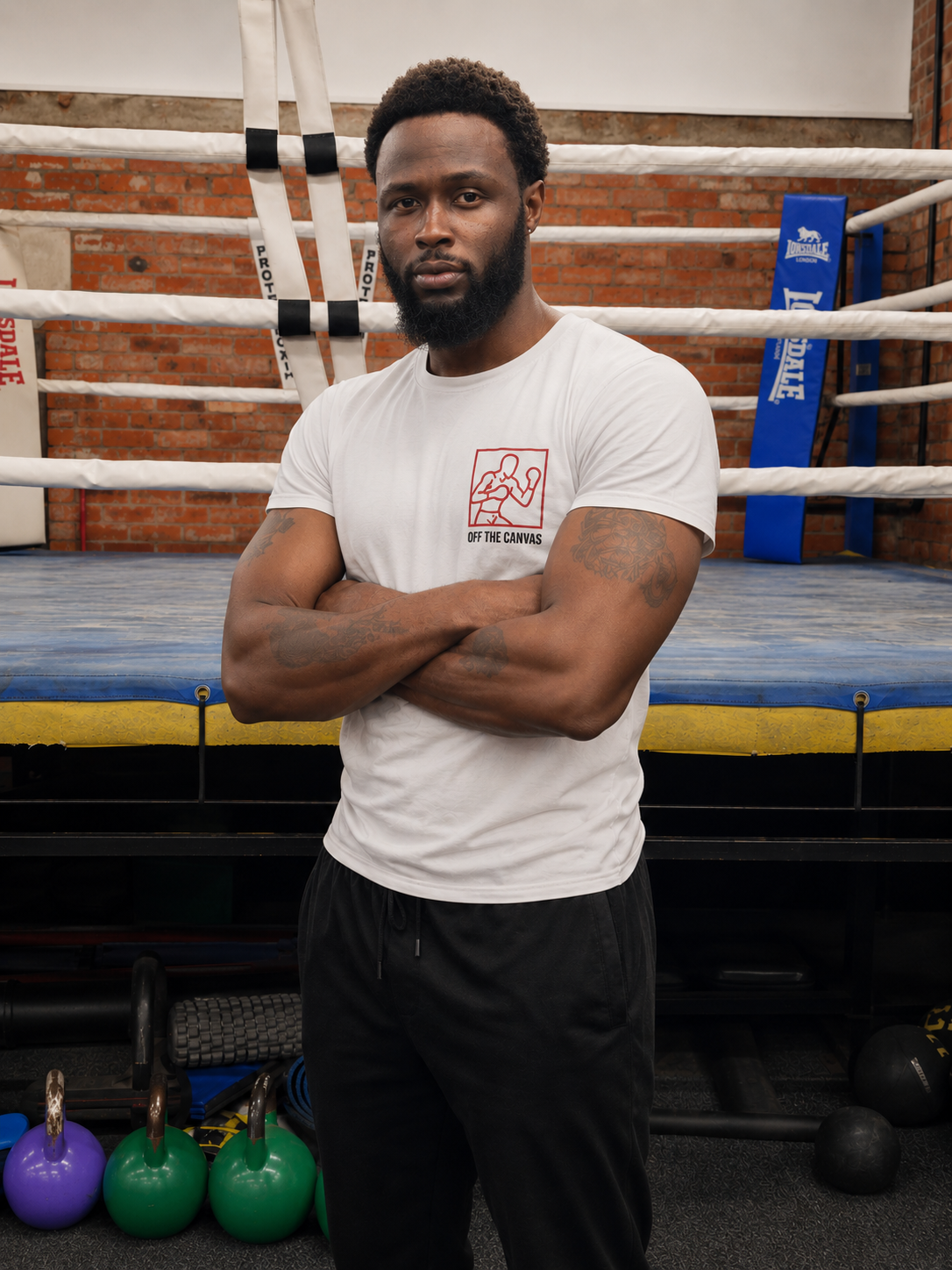 Luis Palmer, founder of Off The Canvas CIC, standing beside a boxing ring
